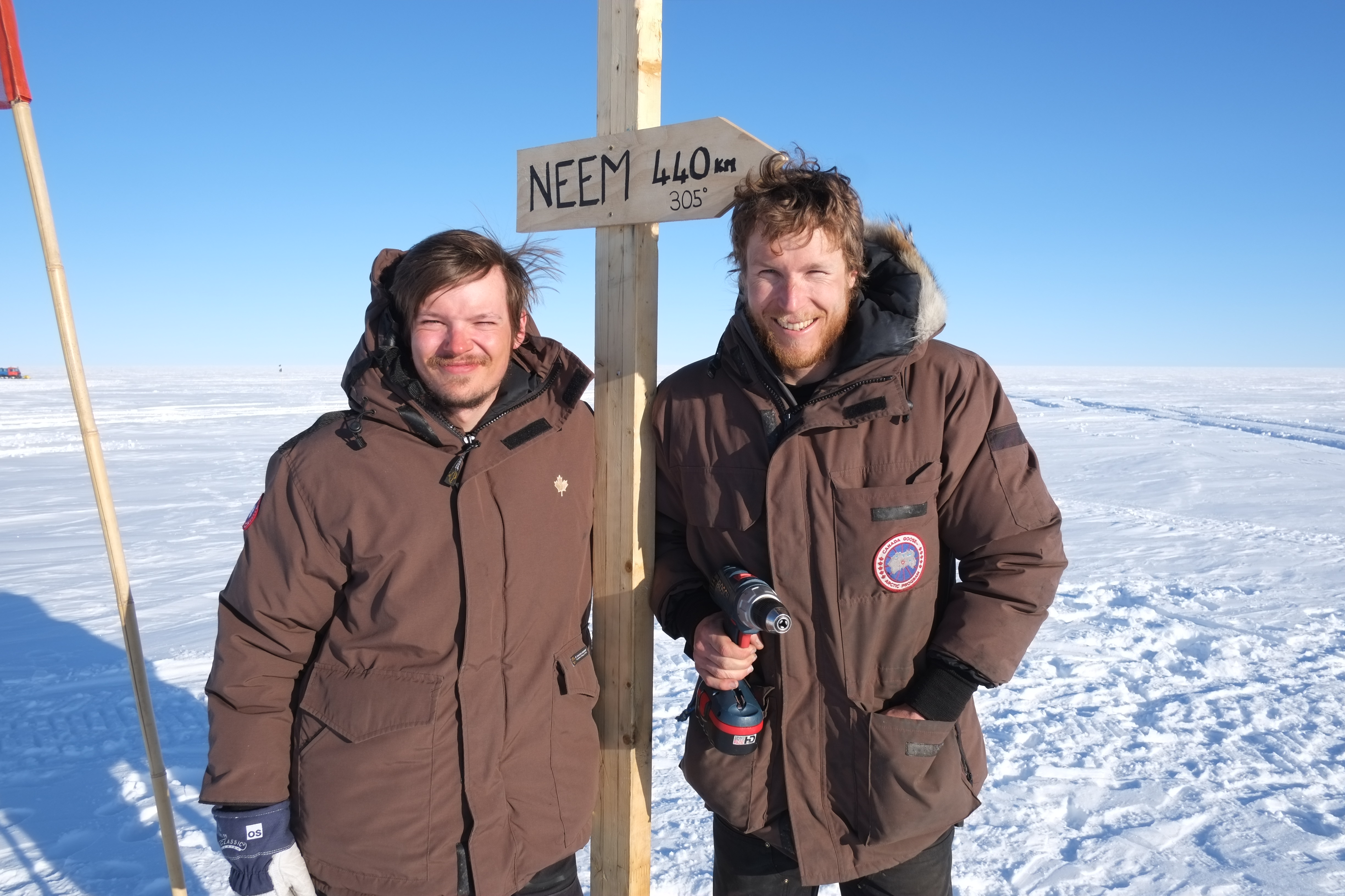 Mathias and Joel at the new road sign in the middle of EGRIP camp. It points to NEEM 440 km away